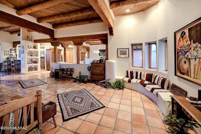 living room featuring wood ceiling, beam ceiling, light tile patterned floors, and ornate columns