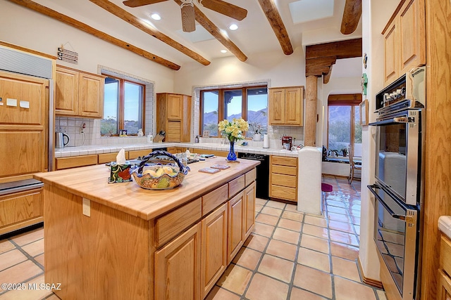 kitchen featuring stainless steel double oven, tasteful backsplash, a center island, and dishwasher