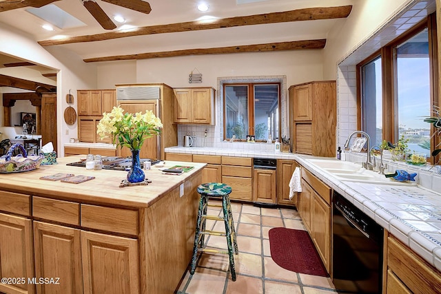 kitchen with sink, dishwasher, a kitchen island, beam ceiling, and decorative backsplash