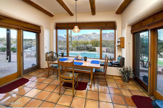 sunroom with a mountain view and beam ceiling