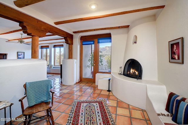 tiled foyer entrance featuring beam ceiling and a large fireplace