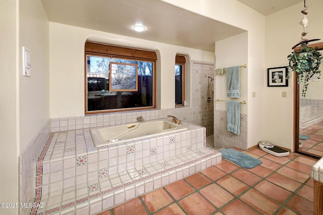 bathroom featuring a relaxing tiled tub and tile patterned floors