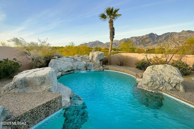 view of swimming pool featuring pool water feature and a mountain view