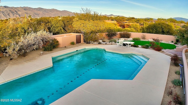 view of swimming pool featuring a mountain view and a patio