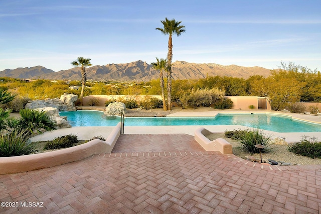 view of pool with pool water feature, a mountain view, and a patio