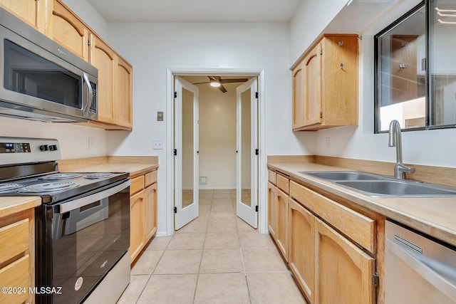 kitchen with french doors, sink, light brown cabinetry, light tile patterned flooring, and stainless steel appliances