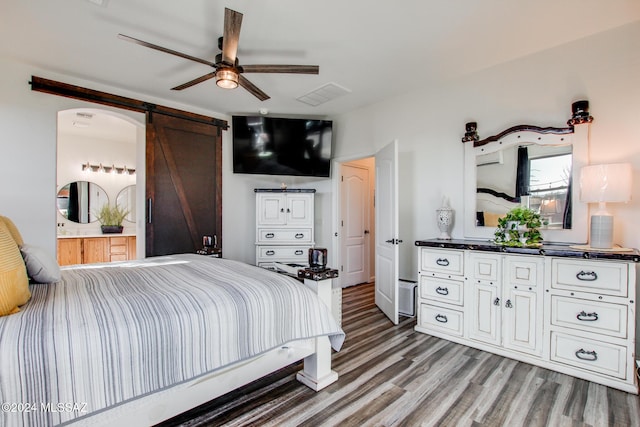 14286 E Lazy Jake Ln, Vail, AZ 85641 - bedroom featuring a barn door, ceiling fan, ensuite bath, and light wood-type flooring