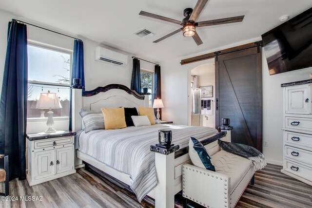 14286 E Lazy Jake Ln, Vail, AZ 85641 - bedroom featuring hardwood / wood-style floors, a barn door, an AC wall unit, and ceiling fan