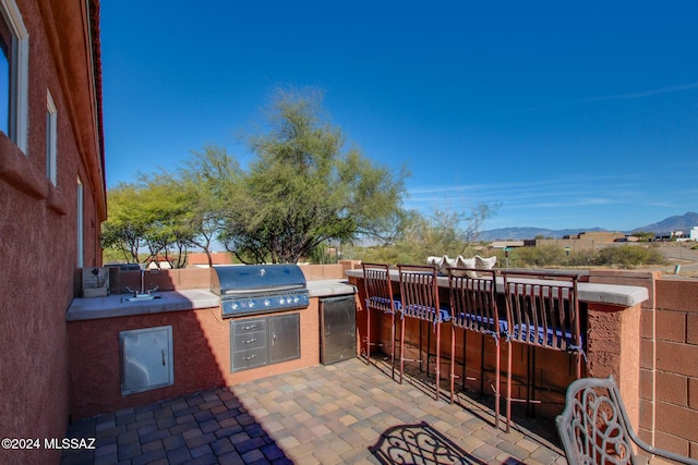 view of patio featuring area for grilling, a mountain view, and grilling area