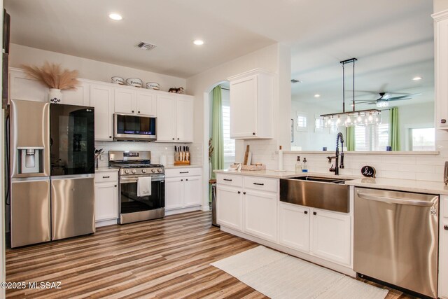 14286 E Lazy Jake Ln, Vail, AZ 85641 - kitchen with backsplash, sink, white cabinetry, and stainless steel appliances