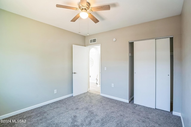 unfurnished bedroom featuring carpet, ceiling fan, and a closet