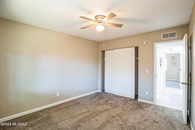 unfurnished bedroom with carpet flooring, ceiling fan, and a closet