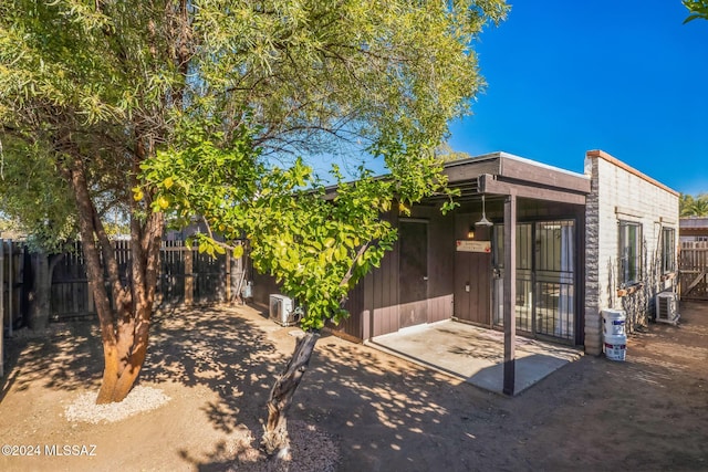 back of property with cooling unit and a patio area