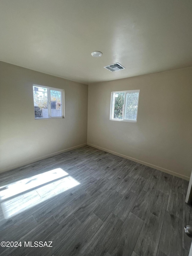 unfurnished room with a wealth of natural light and dark hardwood / wood-style floors