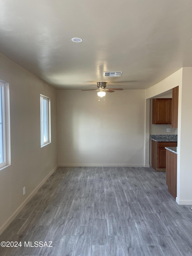 unfurnished living room with ceiling fan and wood-type flooring