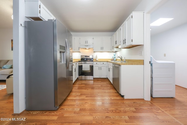 kitchen with sink, white cabinets, stainless steel appliances, and light wood-type flooring