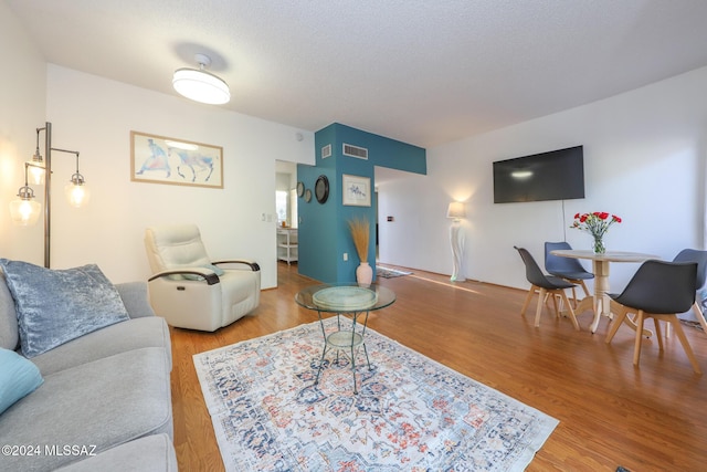 living room featuring hardwood / wood-style flooring and a textured ceiling