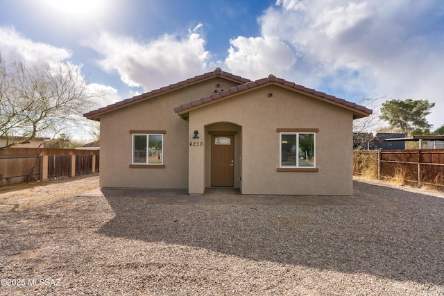 back of property with fence and stucco siding