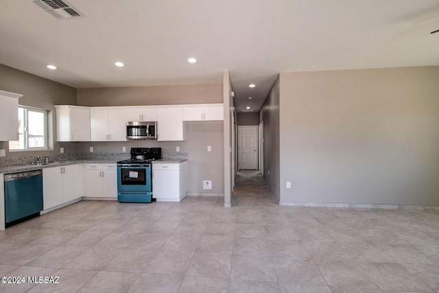 kitchen with white cabinets, sink, light stone countertops, light tile patterned floors, and stainless steel appliances