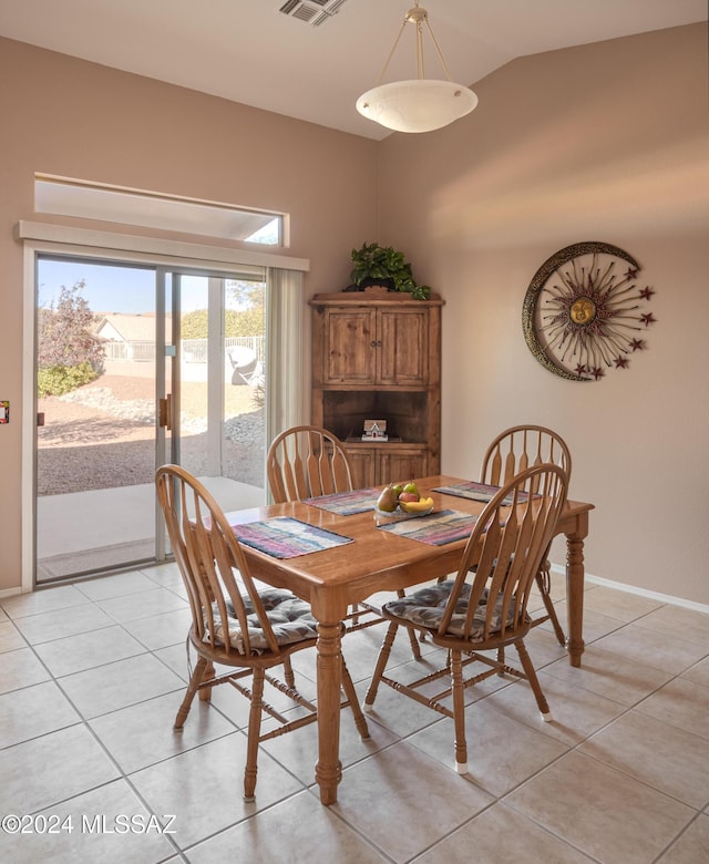 dining room with light tile patterned floors and vaulted ceiling