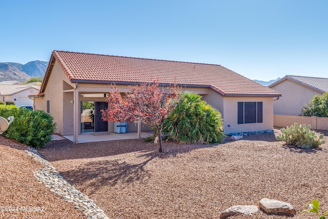 rear view of house with a mountain view and a patio