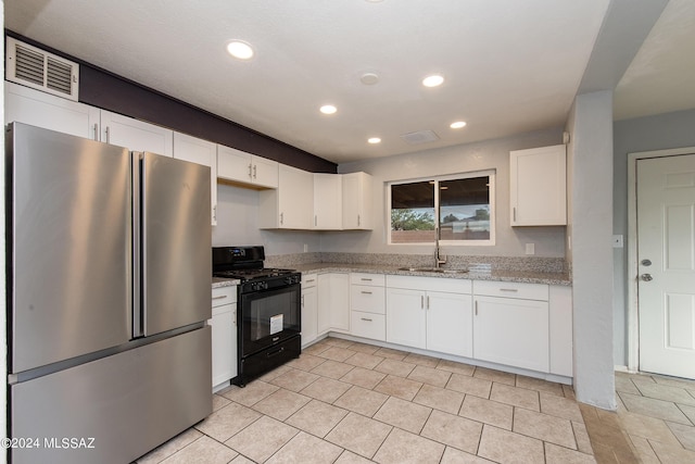 Tucson, AZ 85756 - kitchen with freestanding refrigerator, gas stove, light stone countertops, white cabinetry, and recessed lighting