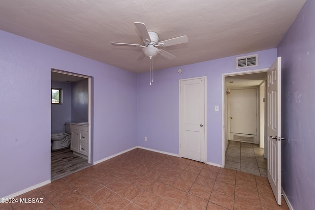 unfurnished bedroom with ensuite bath, ceiling fan, and light tile patterned floors