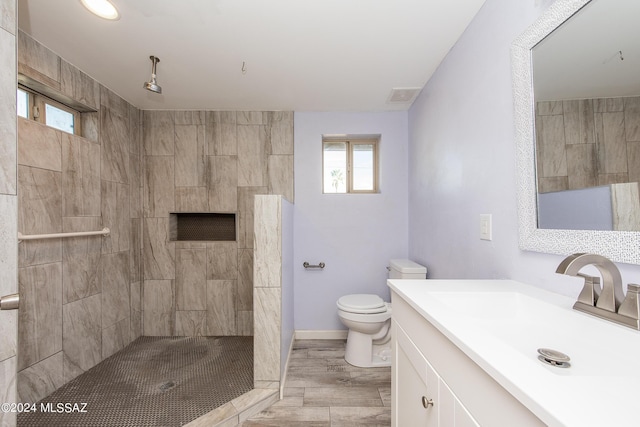 Tucson, AZ 85756 - bathroom with healthy amount of natural light, vanity, tiled shower, and wood finished floors