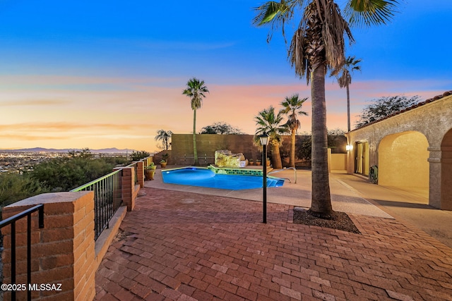 pool at dusk with a patio