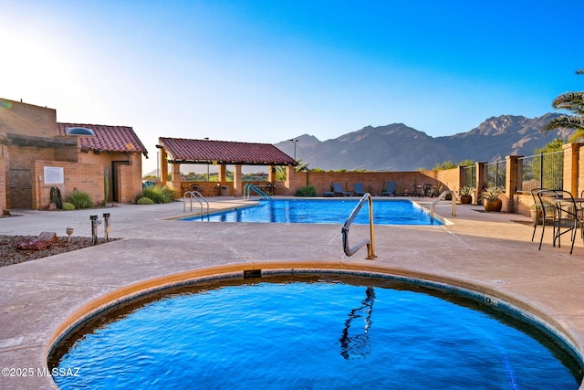 view of swimming pool featuring a gazebo, a mountain view, a community hot tub, and a patio