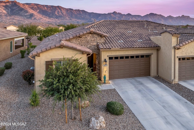 view of front of home with a mountain view and a garage