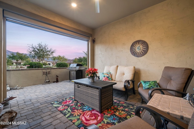 patio terrace at dusk with an outdoor living space and grilling area