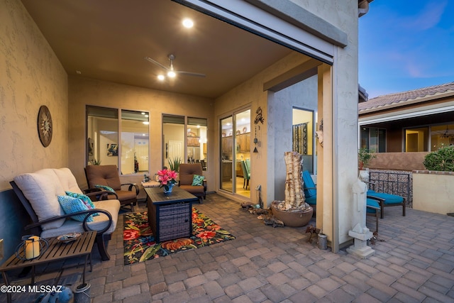 patio terrace at dusk featuring an outdoor living space and ceiling fan