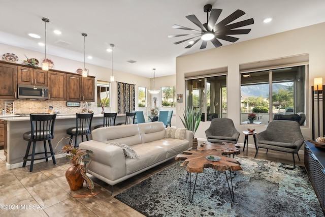 living room featuring ceiling fan and a healthy amount of sunlight