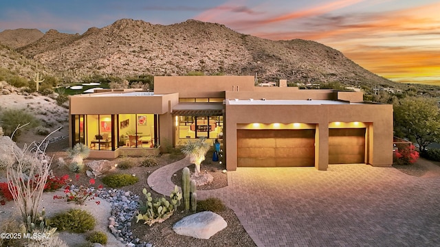 pueblo-style home with a mountain view and a garage