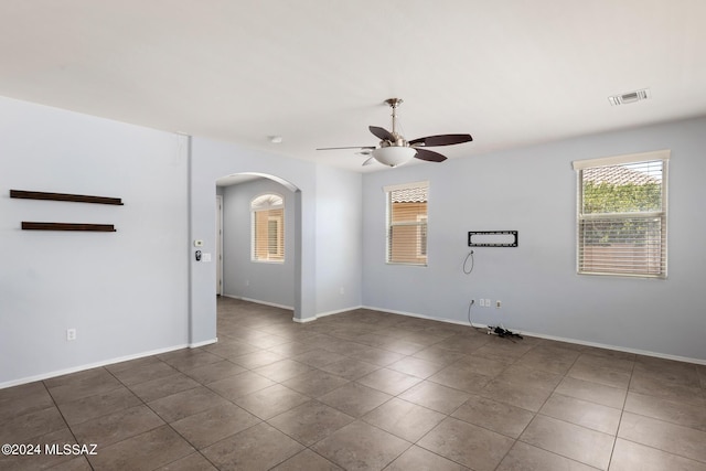 tiled empty room featuring ceiling fan