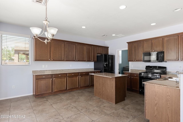 kitchen featuring black appliances, a center island, a notable chandelier, pendant lighting, and sink