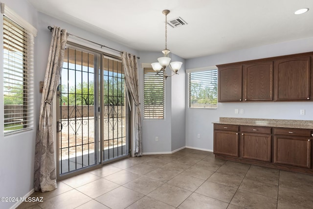 kitchen with decorative light fixtures, light tile patterned floors, and a notable chandelier