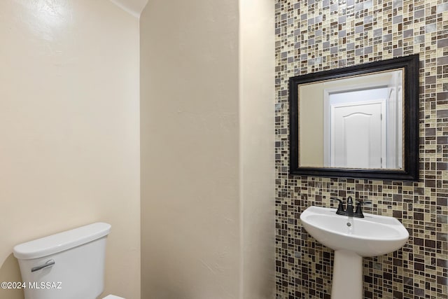 bathroom with tile walls, toilet, and tasteful backsplash