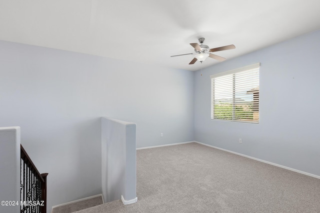 carpeted spare room featuring ceiling fan