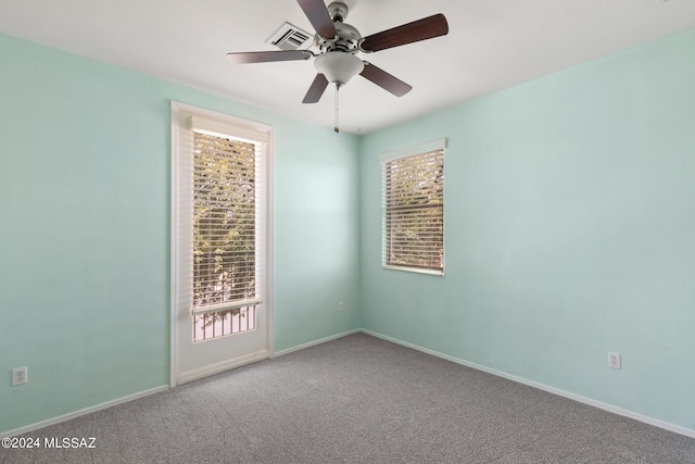 carpeted spare room featuring ceiling fan