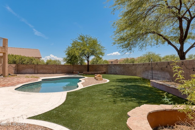 view of pool featuring a lawn and a patio