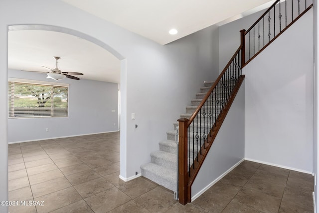 stairway featuring ceiling fan