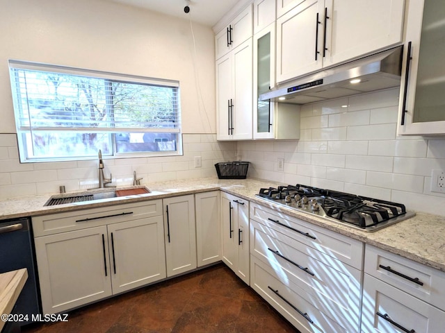 kitchen with sink, tasteful backsplash, light stone counters, white cabinets, and appliances with stainless steel finishes