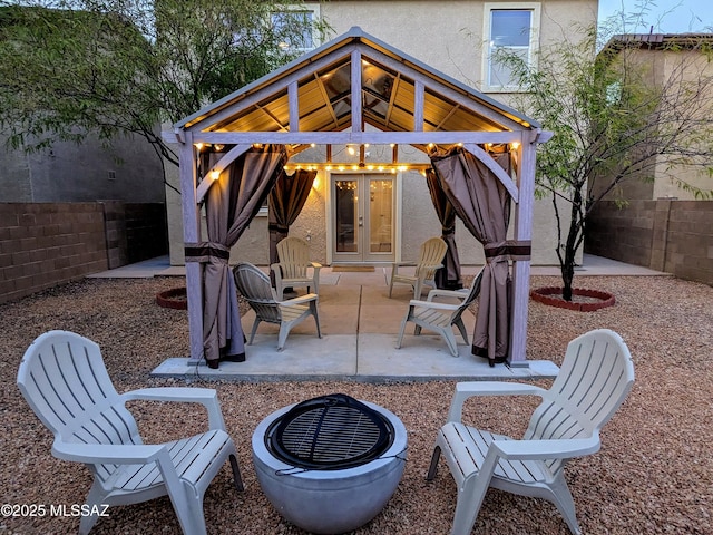 view of patio with a gazebo, a fire pit, and french doors