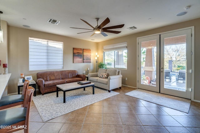 tiled living room with ceiling fan and french doors