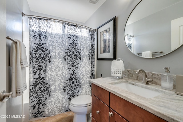 full bathroom featuring shower / tub combo, vanity, and toilet