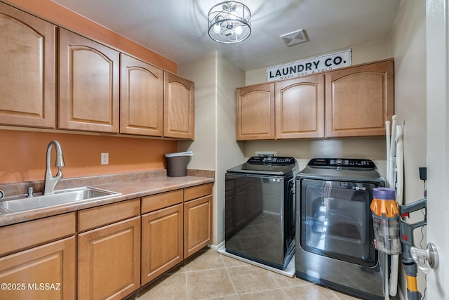 laundry area featuring sink, light tile patterned floors, cabinets, and independent washer and dryer