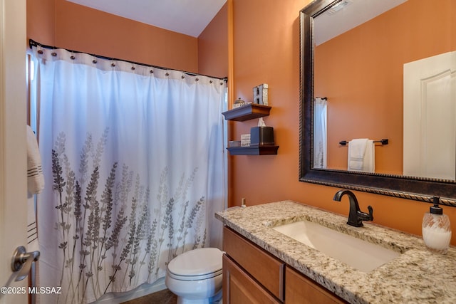 bathroom featuring curtained shower, vanity, and toilet