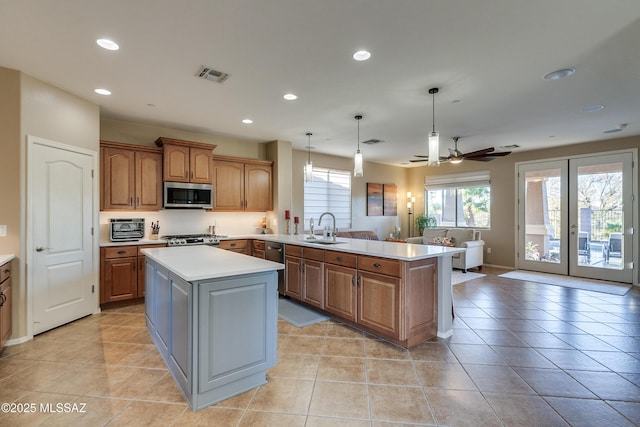 kitchen featuring kitchen peninsula, stainless steel appliances, ceiling fan, sink, and hanging light fixtures